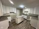 Well-lit kitchen with white cabinets, granite countertops and a stylish island at 3302 N Butler Ave, Indianapolis, IN 46218