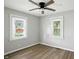 Bedroom with wood-look flooring, ceiling fan, and sun-filled windows at 3609 N Keystone Ave, Indianapolis, IN 46218