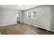 Sun-filled living room with wood-look floors that flows into the kitchen space at 3609 N Keystone Ave, Indianapolis, IN 46218