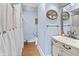 Charming bathroom with a decorative mirror, wood look floors, and blue colored walls at 38 W Main St, Brownsburg, IN 46112