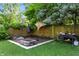 Backyard featuring a brick patio with a fire pit, a grill, and green landscaping at 4023 N Arlington Ave, Indianapolis, IN 46226
