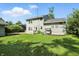 Spacious backyard with a large lawn, mature trees, and a cozy swing for relaxation at 4023 N Arlington Ave, Indianapolis, IN 46226