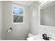Bright bathroom with white walls, toilet, and a vanity with a mirror and updated fixtures at 4023 N Arlington Ave, Indianapolis, IN 46226