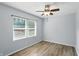 This bedroom features wood floors, a ceiling fan, and a window providing natural light at 4023 N Arlington Ave, Indianapolis, IN 46226