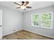 This bedroom features wood floors, a ceiling fan, and a window providing natural light at 4023 N Arlington Ave, Indianapolis, IN 46226