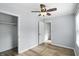 Bright bedroom featuring hardwood floors, a ceiling fan, closet, and light-colored walls at 4023 N Arlington Ave, Indianapolis, IN 46226