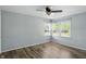 Bright bedroom featuring hardwood floors, a ceiling fan, and ample natural light from three windows at 4023 N Arlington Ave, Indianapolis, IN 46226