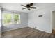 Comfortable bedroom featuring hardwood floors, a ceiling fan, and a large window at 4023 N Arlington Ave, Indianapolis, IN 46226