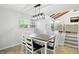 Bright dining area with views of the backyard, modern lighting, a table and access to the living room at 4023 N Arlington Ave, Indianapolis, IN 46226