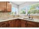 Bright kitchen with stainless steel sink, granite countertops, tile backsplash, and wood cabinets at 4023 N Arlington Ave, Indianapolis, IN 46226