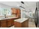 Bright kitchen with a large island, tan backsplash, stainless steel refrigerator, and modern lighting at 4023 N Arlington Ave, Indianapolis, IN 46226