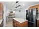 Spacious kitchen with island, wooden cabinets, stainless steel fridge, and adjacent dining area at 4023 N Arlington Ave, Indianapolis, IN 46226