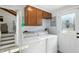 Functional laundry room with white washer and dryer, cabinets, and access to the staircase at 4023 N Arlington Ave, Indianapolis, IN 46226