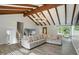 Bright living room features vaulted ceiling, exposed beams, stylish chandelier, and hardwood floors at 4023 N Arlington Ave, Indianapolis, IN 46226
