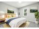 Cozy bedroom featuring a bed with plush pillows, decorative artwork, and natural light from a window at 452 N Fenton Ave, Indianapolis, IN 46219