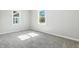 Empty bedroom with two windows letting in light over neutral walls and carpeted floor at 452 N Fenton Ave, Indianapolis, IN 46219