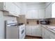 Cozy kitchen featuring white cabinets, laminate countertops, white appliances and dark hardwood flooring at 4625 Beth Ann Dr, Indianapolis, IN 46221