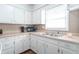 Clean kitchen featuring white cabinetry, laminate countertops, stainless steel sink and neutral backsplash at 4625 Beth Ann Dr, Indianapolis, IN 46221