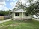 Inviting home featuring a charming covered porch, classic green trim, and well-maintained lawn at 492 S Livingston Ave, Indianapolis, IN 46241