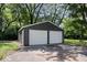 Exterior view of a gray two-car garage with white doors and an asphalt driveway at 5407 Adelaide St, Indianapolis, IN 46203