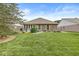 Lush backyard with green lawn and garden, plus brick exterior with awning-covered patio at 5659 Augusta Woods Dr, Plainfield, IN 46168