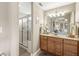 Bathroom with wooden cabinets, double vanity, large mirror and a glass enclosed shower at 5659 Augusta Woods Dr, Plainfield, IN 46168
