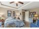 Bedroom with decorative tray ceiling, ceiling fan, a blue quilt bedspread, and assorted decor at 5659 Augusta Woods Dr, Plainfield, IN 46168