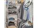 Walk-in closet with built-in shelves filled with folded and hanging clothes and personal items at 5659 Augusta Woods Dr, Plainfield, IN 46168