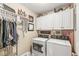 Functional laundry room with a washer, dryer, and storage cabinets at 5659 Augusta Woods Dr, Plainfield, IN 46168