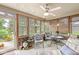Sunroom with a ceiling fan, red brick wall, and an outdoor view through the windows at 5659 Augusta Woods Dr, Plainfield, IN 46168