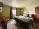 Comfortable bedroom featuring an olive green accent wall, large bed, and window with colorful curtains at 5965 Deerwood Ct, Indianapolis, IN 46254