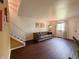 Well-lit living room featuring hardwood floors, a comfortable sofa, and a staircase at 5965 Deerwood Ct, Indianapolis, IN 46254