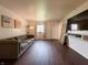 Bright living room with dark wood floors, grey sofa, and TV at 5965 Deerwood Ct, Indianapolis, IN 46254