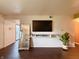 Stylish living room featuring dark hardwood floors, a mounted TV, and a unique floor mirror at 5965 Deerwood Ct, Indianapolis, IN 46254