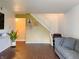 Bright living room featuring a staircase, hardwood floors, and a comfortable grey sofa at 5965 Deerwood Ct, Indianapolis, IN 46254