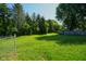 Backyard with ample green space, mature trees, and a fenced perimeter at 6029 Sycamore Forge Dr, Indianapolis, IN 46254
