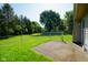 Fenced backyard with green grass, mature trees, and a concrete patio at 6029 Sycamore Forge Dr, Indianapolis, IN 46254