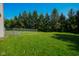 Fenced backyard features a well-maintained lawn and mature trees at 6029 Sycamore Forge Dr, Indianapolis, IN 46254