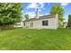 Well maintained backyard featuring a lawn, concrete patio with chairs and trees providing shade at 619 Cahill Ln, Indianapolis, IN 46214