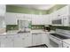 Well-lit kitchen featuring white cabinetry, stainless steel appliances, and a sink overlooking backyard at 619 Cahill Ln, Indianapolis, IN 46214