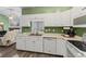 Charming kitchen featuring white cabinetry, stainless steel appliances, and laminate flooring at 619 Cahill Ln, Indianapolis, IN 46214