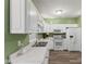 A bright kitchen with white appliances and ample counter space for meal preparation and storage at 619 Cahill Ln, Indianapolis, IN 46214