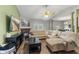 Bright living room with plush sectional sofa, fireplace, ceiling fan, and adjacent dining area at 619 Cahill Ln, Indianapolis, IN 46214