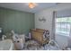 Charming Bedroom with soft green walls, a cozy crib, and comfortable seating area at 740 Springmill Dr, Mooresville, IN 46158