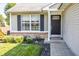 Close-up view of a home's black front door, flanked by a flower garden and a well-maintained lawn at 740 Springmill Dr, Mooresville, IN 46158