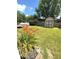 Spacious backyard featuring a shed, lush green grass, and a blooming flower bed at 8425 Brook Pointe Ct, Indianapolis, IN 46234