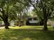 Traditional two-story home boasts a lush green lawn and mature trees that provide ample shade at 9138 E 18Th St, Indianapolis, IN 46229