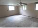 Spacious living room featuring neutral carpeting, light colored walls, ceiling fan, and natural light from several windows at 9138 E 18Th St, Indianapolis, IN 46229