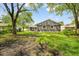 Exterior shot of the home's backyard, highlighting the lawn and mature trees at 9319 Rochelle Dr, Indianapolis, IN 46235