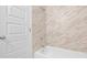 Bathroom features a white tub with tile walls, perfect for relaxation and rejuvenation at 9319 Rochelle Dr, Indianapolis, IN 46235